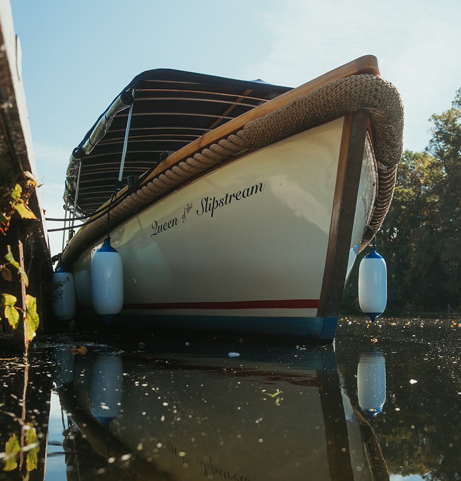 Queen of the Slipstream reflected in still water at her mooring