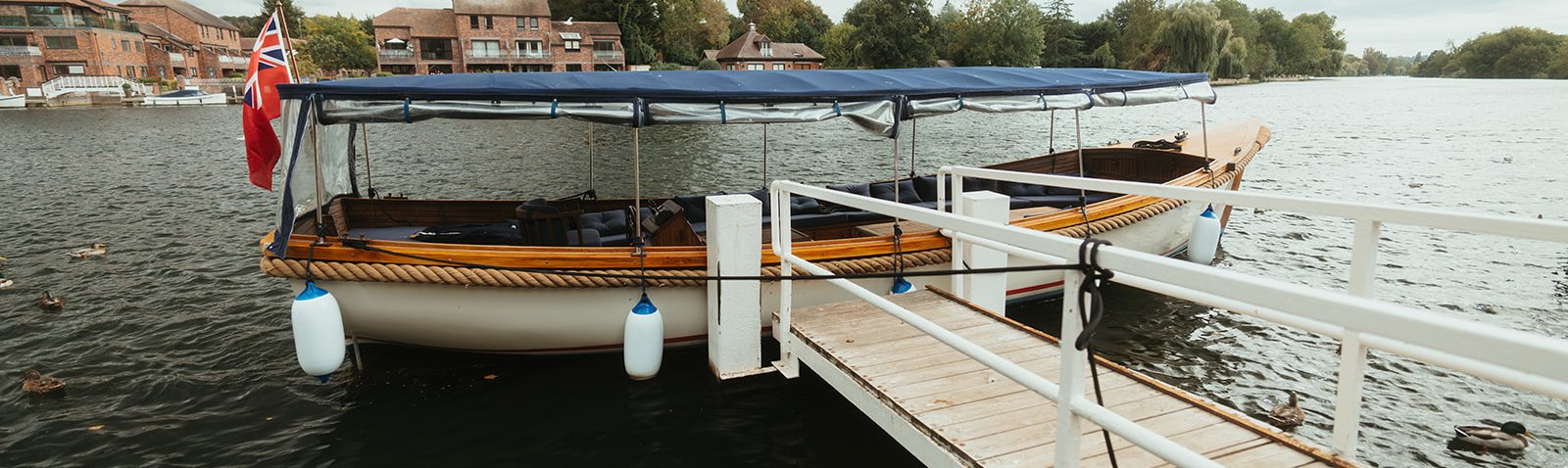 Queen of the Slipstream waiting at a riverside jetty in Marlow